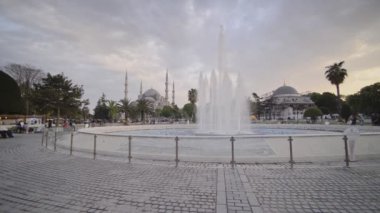 View of the Blue Mosque, behind fountains, Istanbul, Turkey, on a cloudy evening