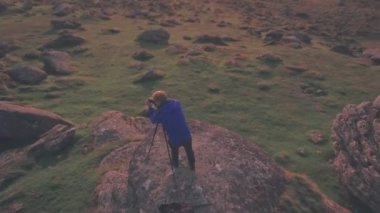 Photographer taking photo in Dartmoor National Park, Devon, England, UK. Aerial drone view
