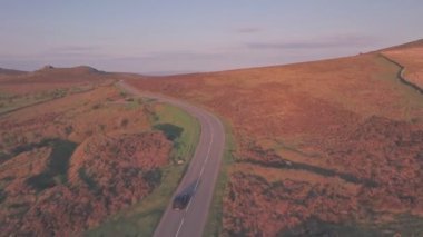 Car driving through Dartmoor National Park, Devon, England, UK. Aerial drone following car