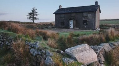 Abandoned countryside house in Dartmoor national park moorland, England, at dusk