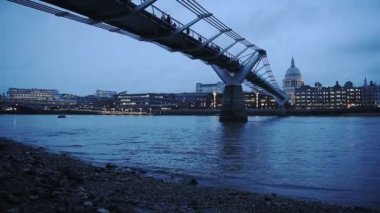 People Walking At The London Millennium Footbridge, A Steel Suspension Bridge Crossing The River Thames In London, UK - Low Angle Shot