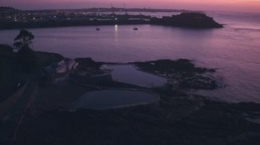 Guernsey tidal bathing pools with Cornet Castle behind at sunrise, Channel Islands, UK. Aerial drone view