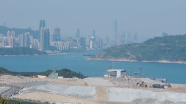A Wide Landfill Area Next To The Coastline Of South China Overlooking The Skyline. -wide shot