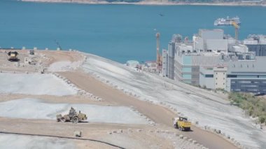 Garbage Truck Driving On the Top Of the Landfill Under The Summer Weather In Hongkong. -wide shot