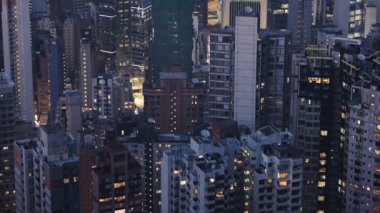 Crowded Skyscarpers Illuminated In The Evening In Hong Kong - aerial shot
