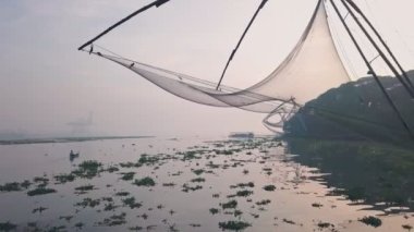 Traditional Chinese fishing nets at sunrise, Fort Kochi, India. Low aerial drone