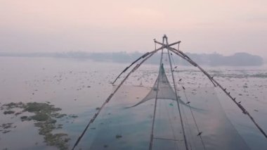 Traditional Chinese fishing nets at sunrise, Fort Kochi in India. Aerial drone view