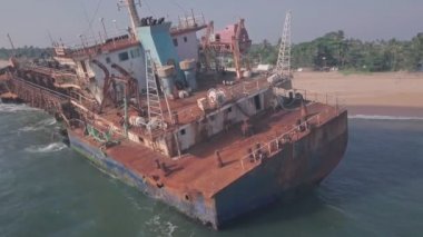 Old shipwreck on a beach near Varkala in Kerala, India. Low aerial drone view