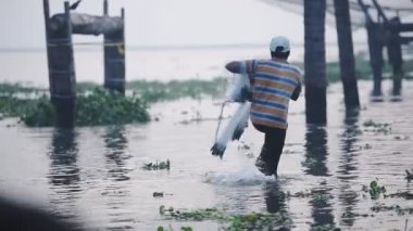 Local man throwing a traditional chinese fishing net, Fort Kochi, India