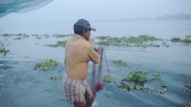 Local man fishing with traditional chinese nets, Fort Kochi, India