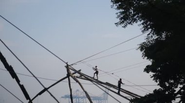 Local men fishing with traditional chinese fishing nets, Fort Kochi, India, at dusk
