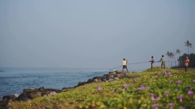 Local fishermen pulling traditional fishing nets, Kappil Beach, Varkala, India