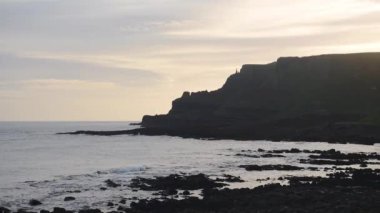 The Beautiful and Peaceful Scenery in Antrim, Ireland Composed Of Calm Sea During Golden Hours - Wide Shot