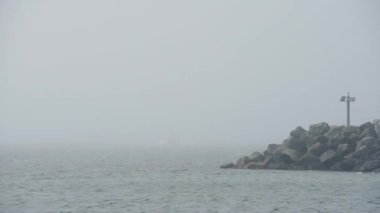 White Ferry Boat Coming Out From The Heavy Fog On Rathlin Island Harbour In Antrim Coast, Northern Ireland.- wide shot