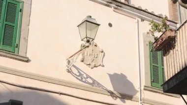 Traditional old street lamp on a historic building wall, Bracciano town, Italy