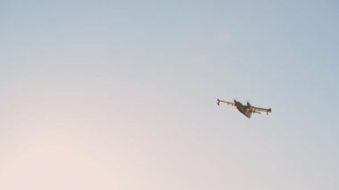 Yellow fire fighting helicopter flying on a clear evening sky