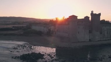 Santa Severa Beach and Castle at sunrise, Province of Rome, Italy. Aerial drone view