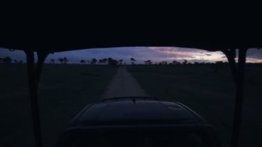 Wildlife safari holiday game drive in Kenya. Driving at night before sunrise in the savanna