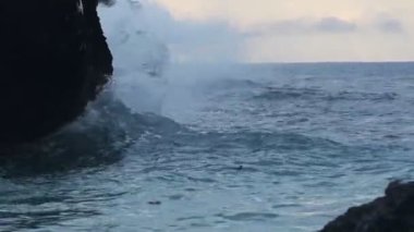 Ocean waves crashing on the cliffy shore, in Watamu Beach, Kenya, at dusk