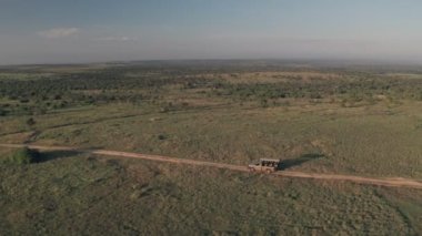 4 wheel drive vehicle on wildlife safari in Kenya. Aerial drone view of safari vacation