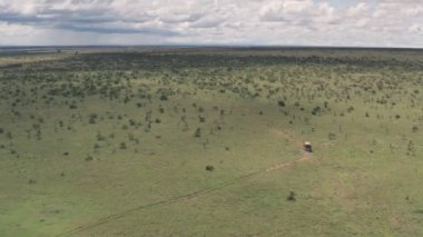 Wildlife holiday in Laikipia, Kenya. Aerial drove view of 4 wheel drive driving through African savanna landscape.