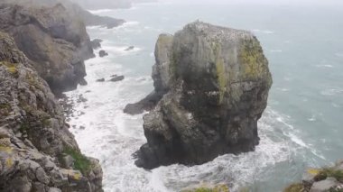 Waves crashing on Elegug Stacks, Pembrokeshire Coast National Park, Wales, on a moody day