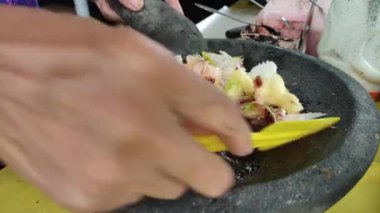 Bir tüccar Rujak baharatlarını karıştırıyor.