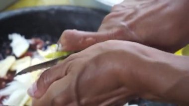 Bir tüccar Rujak baharatlarını karıştırıyor. Rujak, taze meyve ve baharatlardan oluşan tipik bir Endonezya yemeğidir..