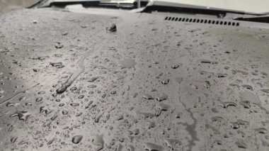 Siyah araba kaputuna yağmur damlaları, yakın çekim