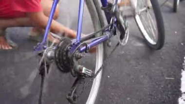 Bali, Endonezya - Mart 04, 2022: Bisiklet oynayan küçük çocuk, gevşek bir zinciri tamir ediyor