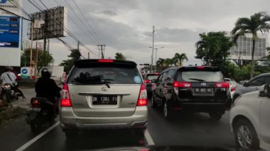 Bali, Endonezya - 21 Mart 2022: Öğleden sonra trafik sıkışıklığında araba. Arabalar ve motosikletler sokakları doldurdu..