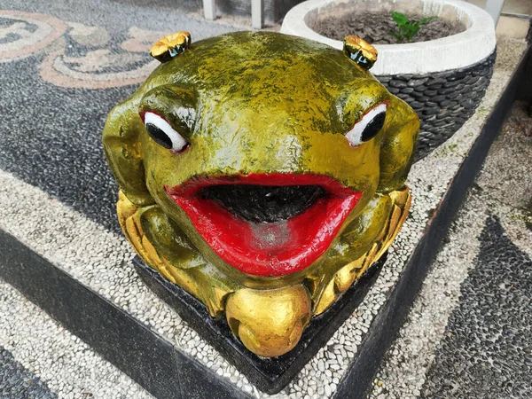 the frog statue is located in front of a restaurant in Jimbaran.