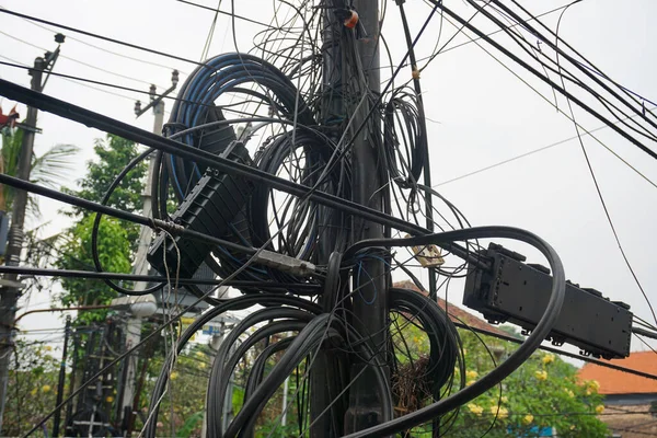 messy electricity wires on the pole, The chaos of cables and wires on an electric pole in Indonesia