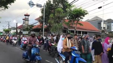 Bali, Indonesia - July 10, 2022: Muslims return from the courtyard of the mosque after completing the Eid al-Adha prayer.