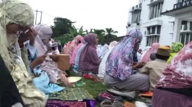 Bali, Indonesia - July 10, 2022: Muslim women are praying Eid al-Adha in the field.