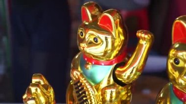 Chinese Lucky Cat sitting on a shop shelf. Considered a bringer of fortune.