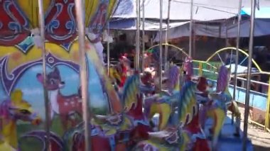 Bali, Indonesia - July 10, 2022: Ride the carousel in the park. Younger children are accompanied by their parents. Carousel in amusement park merry-go-round riding horse.