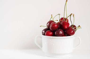 Ripe organic cherries on gray background with copy space. Water drops on ripe juicy cherries