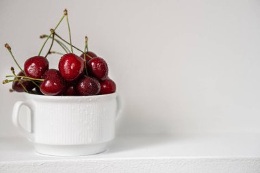 Ripe organic cherries on gray background with copy space. Water drops on ripe juicy cherries