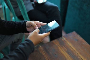Bir adam akıllı telefon tutuyor.