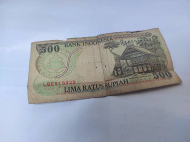 An old Indonesian banknote, five hundred rupiah, 1992, with a picture of a traditional house inside, which is no longer in circulation.