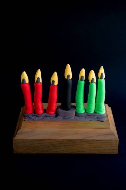 Kinara. Traditional Kwanzaa symbols. Isolated on black background. African American holiday. Hand-sculpted kinara from plasticine
