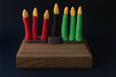 Kinara. Traditional Kwanzaa symbols. Isolated on black background. African American holiday. Hand-sculpted kinara from plasticine