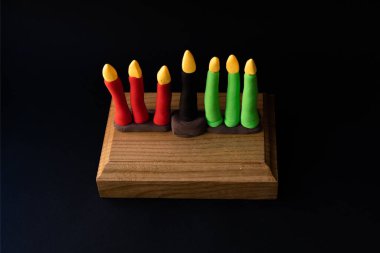 Kinara. Traditional Kwanzaa symbols. Isolated on black background. African American holiday. Hand-sculpted kinara from plasticine