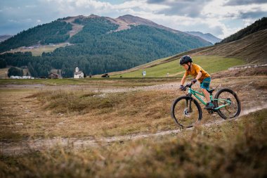 Aktif çocuk bisiklet sürüyor. Dağ bisikleti süren küçük bir binici. Enduro dağlarda at sürüyor..