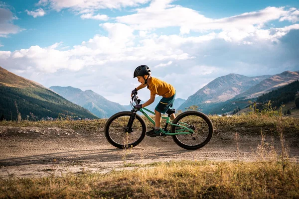 Aktif çocuk bisiklet sürüyor. Dağ bisikleti süren küçük bir binici. Enduro dağlarda at sürüyor..