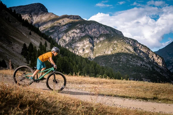Aktif çocuk bisiklet sürüyor. Dağ bisikleti süren küçük bir binici. Enduro dağlarda at sürüyor..