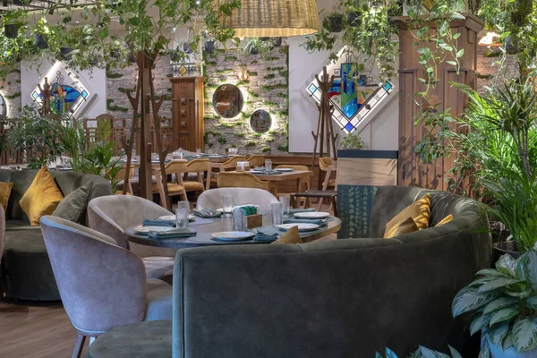 Eco architecture. Floral interior. Green cafe with plants. Urban environment concept. Ecology and green living in city. Modern restaurant covered green plant.