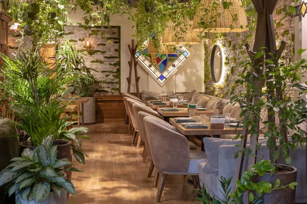 Çevre mimarisi. Çiçekli iç mekan. Bitkileri olan yeşil bir kafe. Şehir çevresi konsepti. Ekoloji ve yeşil şehirde yaşıyor. Modern restoran yeşil bitkiyle kaplı.