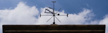 Bottom view of old vane against sky in Wroclaw, banner  clipart